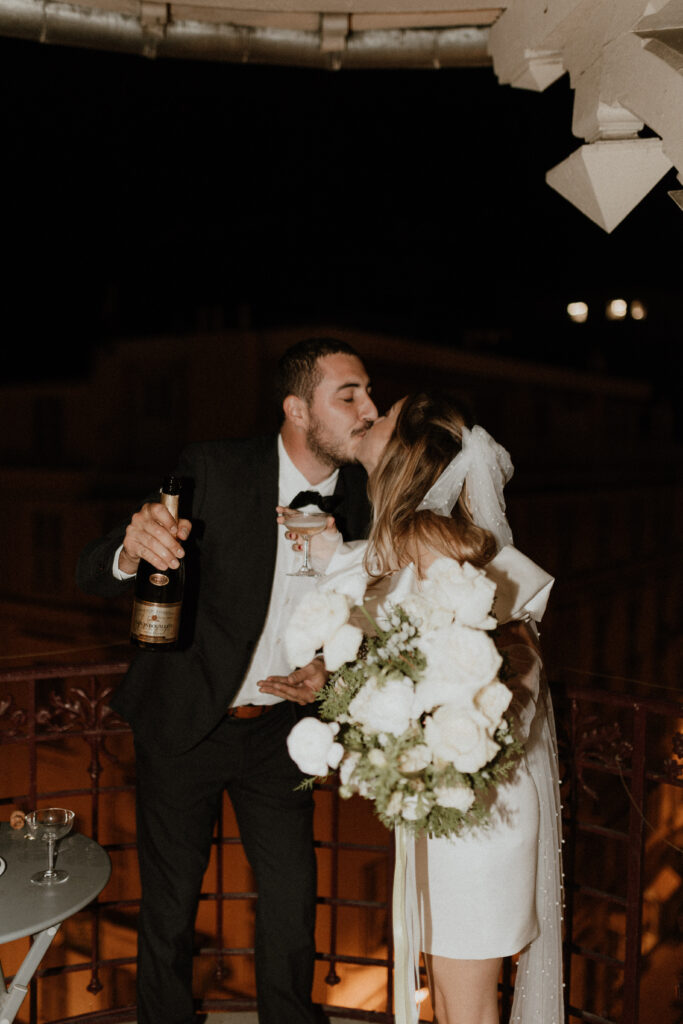 jeunes mariés de nuit avec champagne et bouquet de fleurs