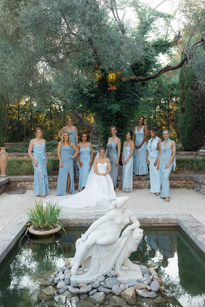 Bride and bridesmaids by a fountain statue in Antibes
